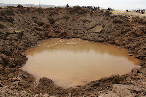 [Crater that formed in the southern Peruvian town of Carangas on September 16, 2007. Image credit: Miguel Carrasco/La Razon/Reuters. http://news.nationalgeographic.com/news/bigphotos/52624256.html]