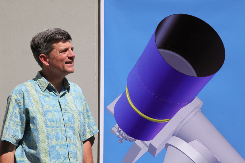 [ATLAS Principal Investigator Dr. John Tonry and a correctly sized image of one of the telescope designs. Image credit: Louise Good, University of Hawaii Institute for Astronomy.]